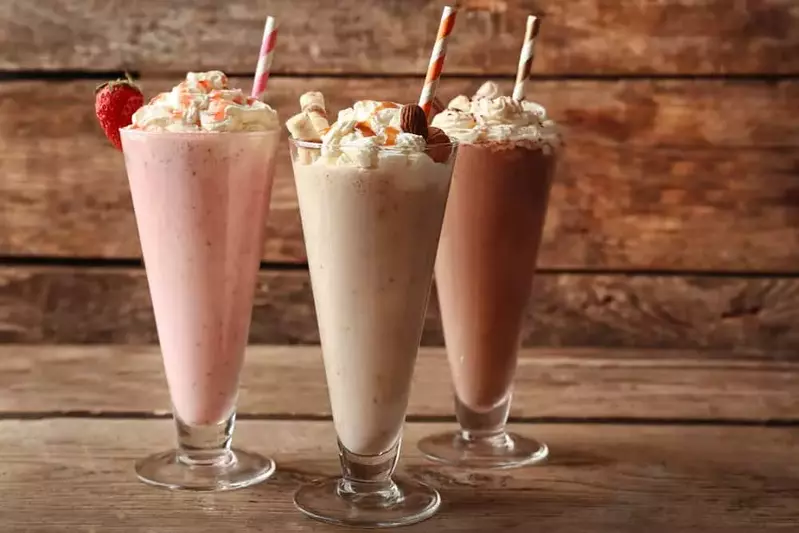 milkshakes sitting on a wooden background