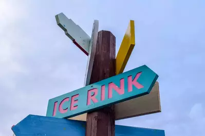 A sign points in the direction of an ice rink.