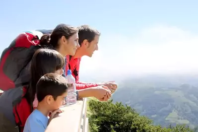 A family enjoying mountain views from the deck of their cabin.