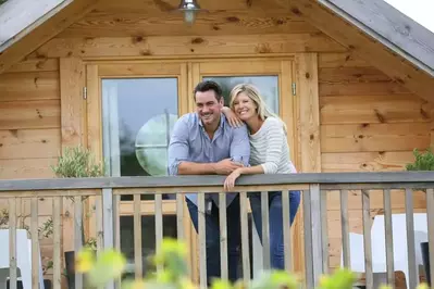 A happy couple enjoying the views from their cabin's deck.