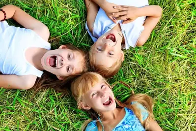 Happy kids posing on the grass outside of their 5 bedroom Gatlinburg cabin.