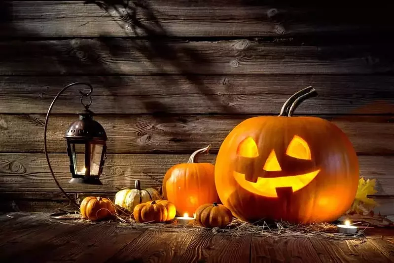 A Halloween display with pumpkins and a lantern