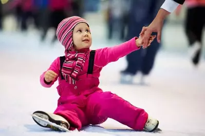 mothers hand helping small child on ice at Ober Gatlinburg