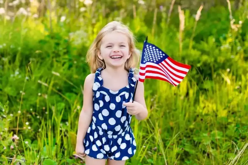 smiling little girl holding american flag at a Gatlinburg cabin