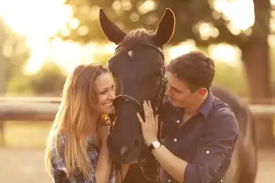 A happy couple and a horse.