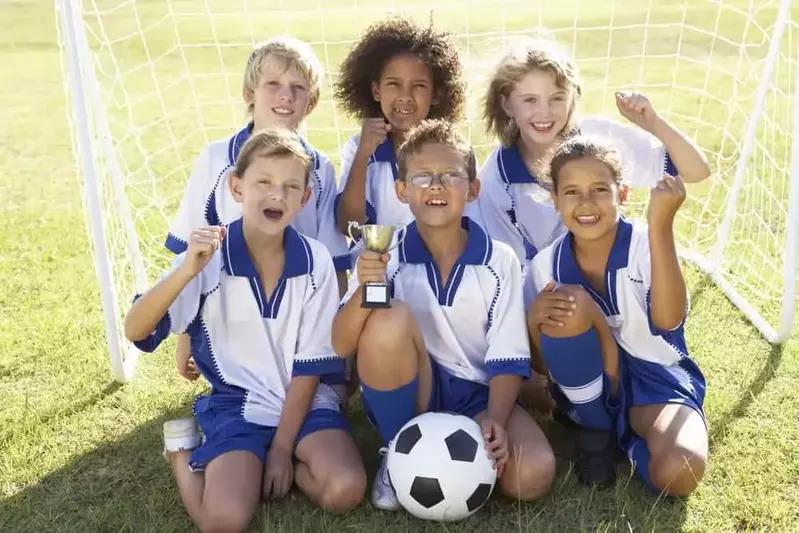 kids posing with soccer trophy