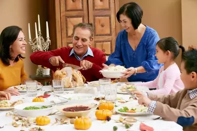 A multi-generational family enjoying Thanksgiving dinner together.